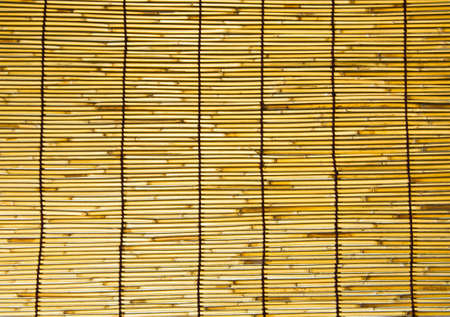 This is a wall of bamboo are woven together in a large sheet の写真素材