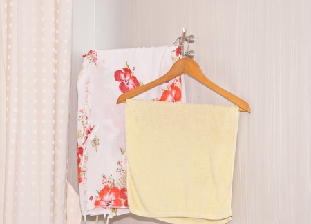 Towel draped on coat hanger in the corner of the room の写真素材