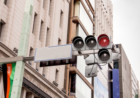 Red color on the traffic light and near buildings.
