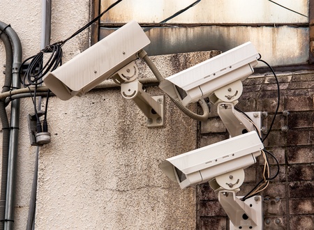Three Security cameras frontal view on concrete wallの写真素材