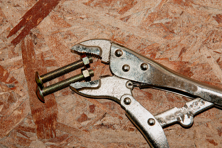 Adjustable wrench and bolt  on wood wall backgroundの写真素材