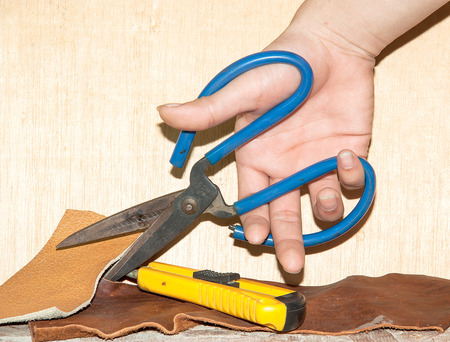 Scissors for cutting leather, placed on a wooden floor 