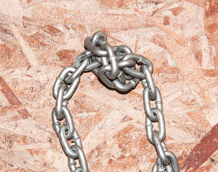 Chains are tightly bound on wooden table 