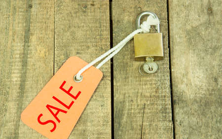 House Key with Sale tag  on a background of plywood.の写真素材