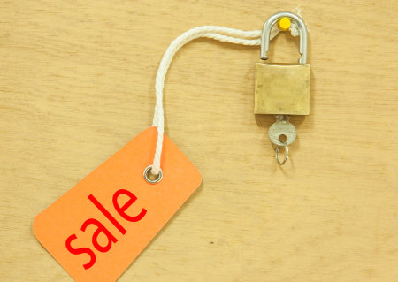 House Key with Sale tag  on a background of plywood.の写真素材