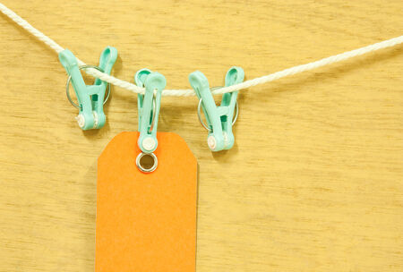 Clothes pegs clamping  blank price tag hang on white rope