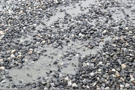 The ground is rocky in a little pond.の写真素材