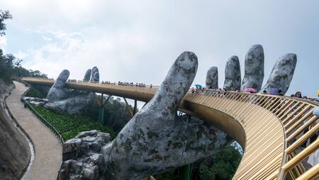 Danang, Vietnam - Jun 3, 2019: The Golden Bridge is lifted by two giant hands in the tourist resort on Ba Na Hill in Da nang, Vietnam.のeditorial素材