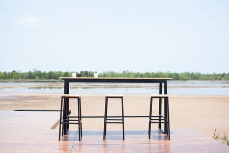 Chairs and tables in the middle of nature, sea, sky and sand.の写真素材