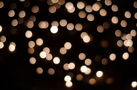 gold and yellow bokeh on black background. blurred bokehの写真素材