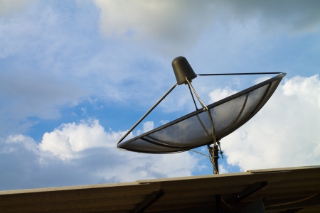 the satelite dish of cable tv for home use on the roof of buildingの写真素材