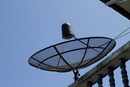 the satelite dish of cable tv for home use on the roof of buildingの写真素材