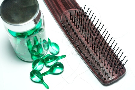 hair vitamins and Hairbrush with Hair Loss on white background