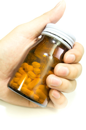 Close up of a hand holding a yellow pill bottleの写真素材