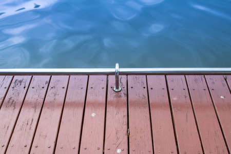 backgrounds of wood floor with guard rail and green waterの写真素材