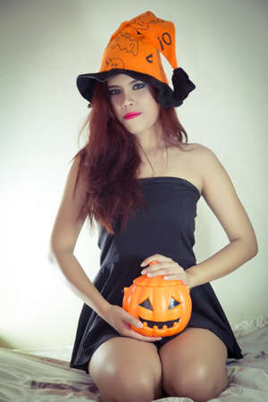 Women's Halloween hat and pumpkin in concept halloweenの写真素材
