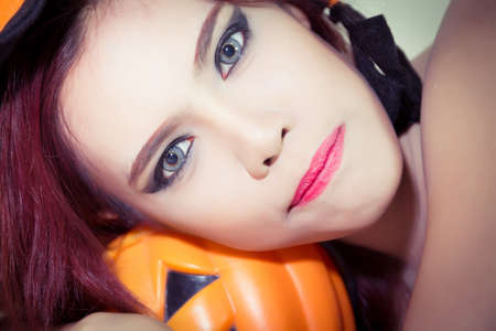 Women's Halloween hat and pumpkin in concept halloweenの写真素材