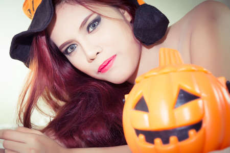Women's Halloween hat and pumpkin in concept halloweenの写真素材