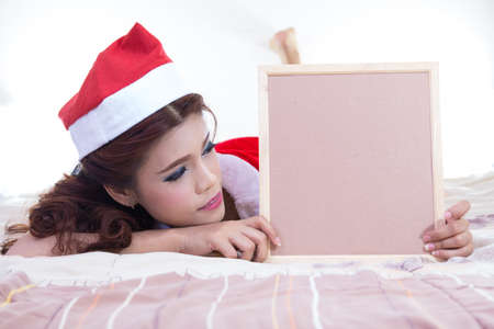 Beautiful women asian hold wood board in red santa dress. christmas conceptの写真素材