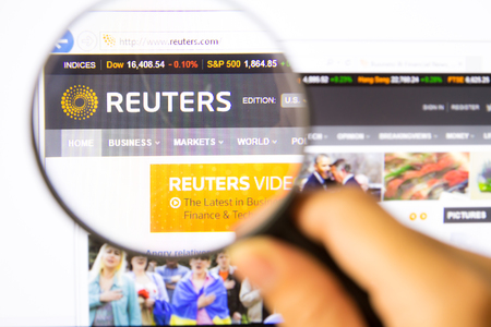 Bangkok,Thailand â APRIL 20, 2014: Photo of Reuters Monitor homepage on a monitor screen through a magnifying glass.のeditorial素材