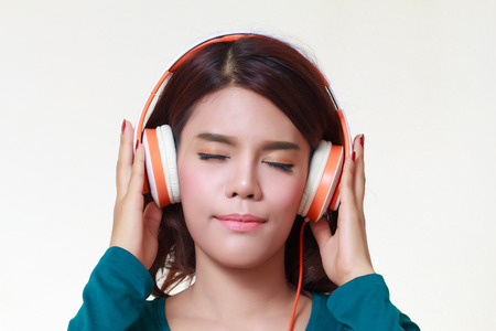 Beautiful young woman with headphones listening to the musicの写真素材