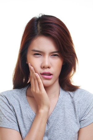 Teen woman pressing her bruised cheek with a painful expression as if she's having a terrible tooth ache.の写真素材