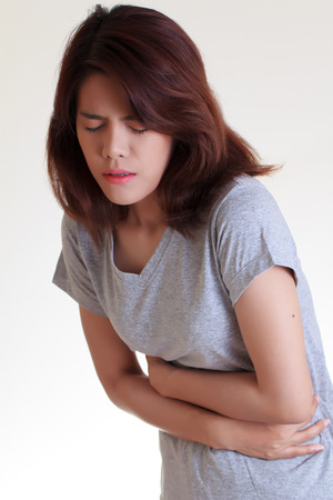 Woman with both palm around waistline to show pain and injury on belly area and stomach ache. Medical health care concept.の写真素材