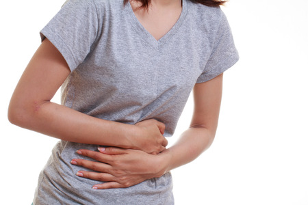 Woman with both palm around waistline to show pain and injury on belly area and stomach ache. Medical health care concept.の写真素材