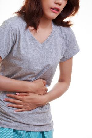 Woman with both palm around waistline to show pain and injury on belly area and stomach ache. Medical health care concept.の写真素材