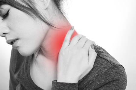 Young woman holding  neck in pain and discomfortの写真素材