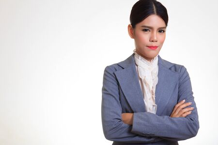 Business woman wearing a suit, standing arms crossed, smiling with confidence.の写真素材