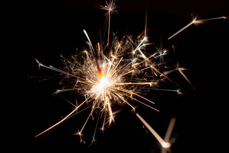 Burning Christmas sparkler on black background, Happy New Yearの写真素材