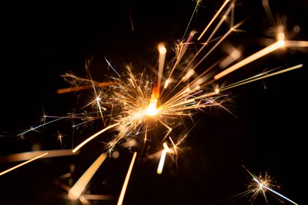 Burning Christmas sparkler on black background, Happy New Yearの写真素材