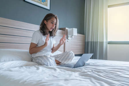 Top View of Beautiful Young Woman Sleeping Cozily on a Bed in His Bedroom at Night. she is playing phone until sleepの写真素材