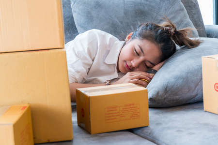Top View of Beautiful Young Woman Sleeping Cozily on a Bed in His Bedroom at Night. she is playing phone until sleepの写真素材