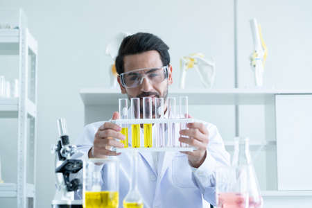 Medical Development Laboratory: Male Scientist Looking Vaccine, Professionals Working in Advanced Scientific Lab doing Medicine, Vaccine, coronavirus covid-19 vaccine developmentの写真素材