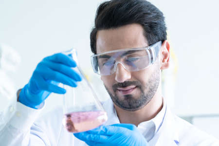 Medical Development Laboratory: Male Scientist Looking Vaccine, Professionals Working in Advanced Scientific Lab doing Medicine, Vaccine, coronavirus covid-19 vaccine developmentの写真素材