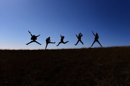 They are jumping while walking on a hill of Doi Mon jong the mountain in Chiang Mai, Thailand.