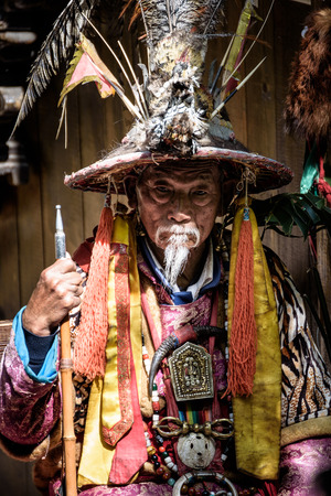 LIJIANG,CHINA - April 22,2016:Old man wearing traditional Chinese dresses to show tourists in Lijiang old town.のeditorial素材