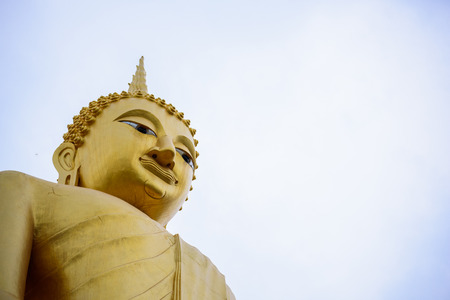 Up angle view of Golden buddha statue with sky background.の写真素材