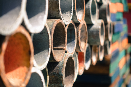 Multi color scaffolding pipe row on shelve in industrial plant or oil and gas platform.