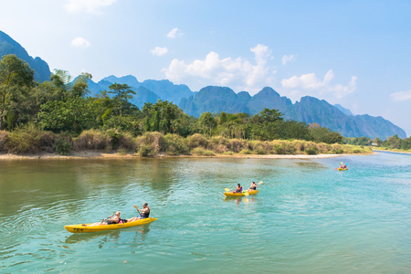 Vang Vieng, Laos - February 17, 2017: Tourists kayaking at Nam Song river, Vang Vieng, Lao with mountains and sky backgroundのeditorial素材