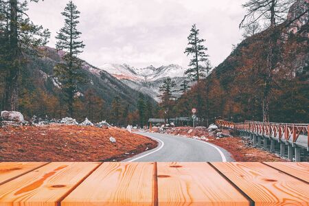 Wooden board empty table in front of blurred background. Perspective brown wood over road in pine trees forest  for mock up  display or montage your products, vintage.の写真素材