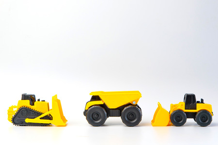 Under construction concept, with group of human toy and heavy duty machinery vehicle on white background with copy space for mocup your product.の写真素材