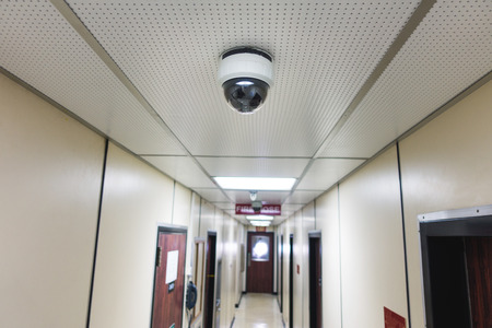 CCTV system security camera or cctv camera on ceiling in apartment room or living quarter. の写真素材