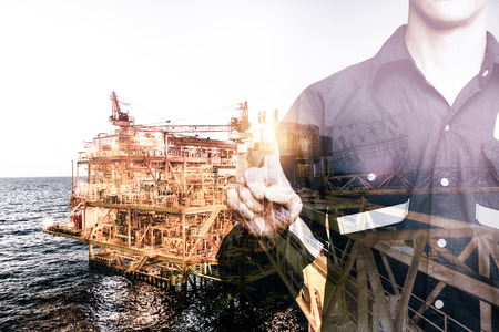 Double exposure of Engineer or Technician man pointing his finger for industry 4.0 concept with offshore oil and gas platform background for industrial business concept.の写真素材