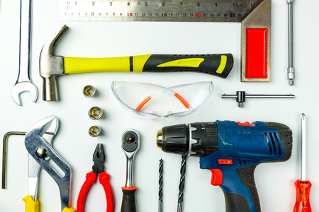 Set of construction tools on white background as wrench, hammer, pliers, socket wrench, spanner, tape measure, electric drill,safety glasses, screwdriver.の写真素材