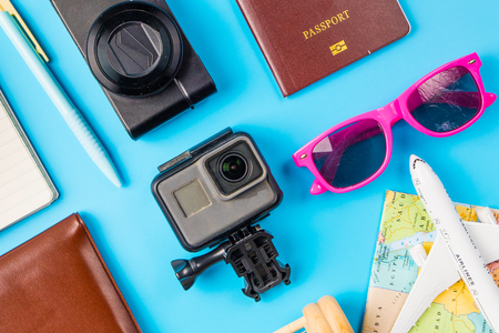 Travel accessories costumes concept for summer vacation trip. Passports, luggage, map, smartphone,sun glasses,camera, note pad, jean on blue.の写真素材