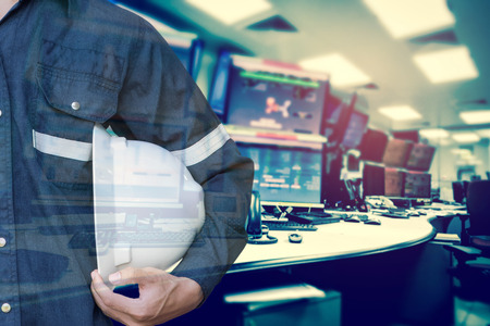 Double exposure of Engineer or Technician man holding safety hat with computer monitor control room for stock and control process industrial business concept.の写真素材