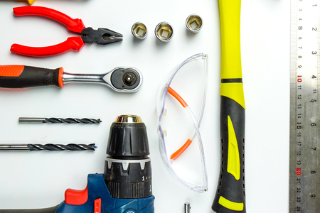 Set of construction tools on white background as wrench, hammer, pliers, socket wrench, spanner, tape measure, electric drill,safety glasses, screwdriver.の写真素材